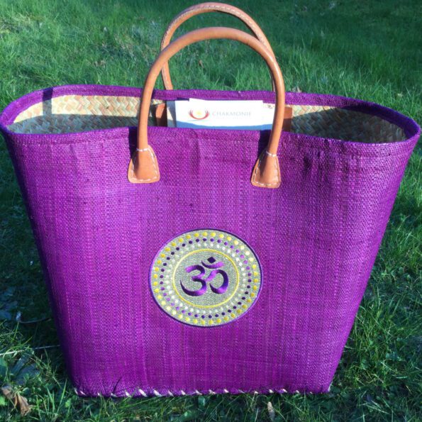 Basket made of raffia and palm leaf with handles with embroidered OM chakra symbol